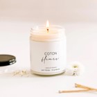Chandelle de soya Coton Fleurs allumée dans un pot en verre au couvercle noir, posée dans un décor lumineux et épuré – flamme douce diffusant un parfum propre et floral, conçu avec Sarah Couture.
