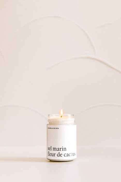 Chandelle de soya Sel marin et Fleur de cactus dans un pot de verre, posée sur un comptoir blanc 