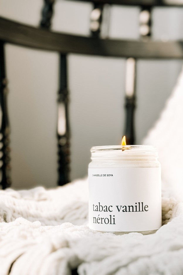 Chandelle de soya Tabac Vanille Néroli allumée, dans un pot en verre  – flamme douce créant une ambiance chaleureuse et élégante, parfum boisé, vanillé et floral, par Marée.