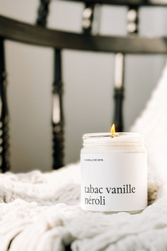 Chandelle de soya Tabac Vanille Néroli allumée, dans un pot en verre  – flamme douce créant une ambiance chaleureuse et élégante, parfum boisé, vanillé et floral, par Marée.