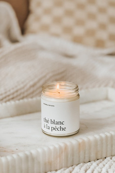 Chandelle de soya Thé Blanc à la Pêche dans un pot en verre transparent avec couvercle blanc, posée sur une surface neutre – chandelle artisanale au parfum fruité et floral, 270 ml, édition Marée.